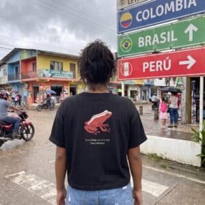 Woman wearing the black Amazon Dart Frog tee, back view, at the Colombia-Brazil-Peru tri-border in Leticia