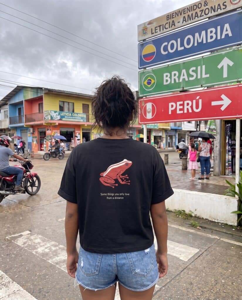 Woman wearing the black Amazon Dart Frog tee, back view, at the Colombia-Brazil-Peru tri-border in Leticia